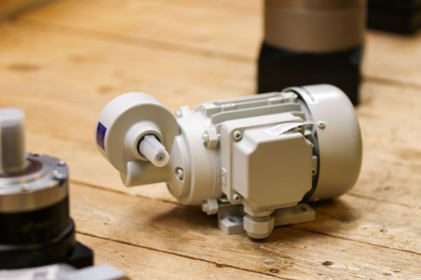 Motorreductor eléctrico con su caja de bornes apoyado sobre un tablero de madera